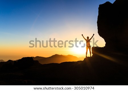 Woman successful hiking climbing silhouette in mountains, motivation and inspiration in beautiful sunset and ocean. Climber arms up outstretched on mountain top looking at inspirational landscape. Royalty-Free Stock Photo #305010974