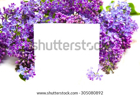 Beautiful bouquet lilacs with card on a white wooden background