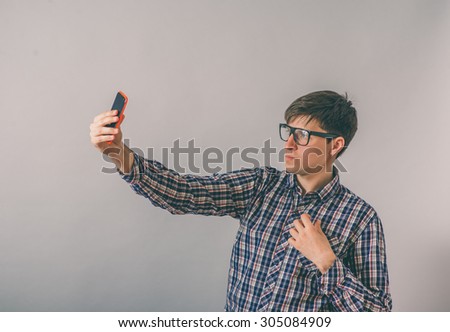 Funny man photographing himself on a smartphone