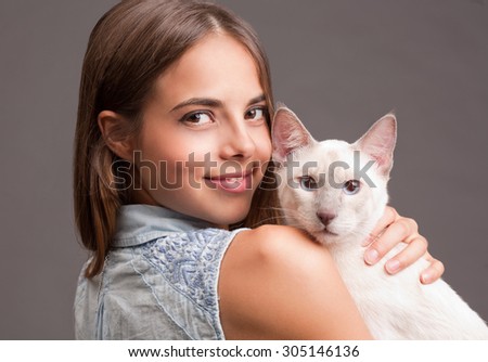 Portrait of a brunette beauty with siamese cat.