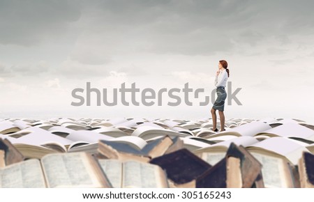 Young businesswoman on pile of old books