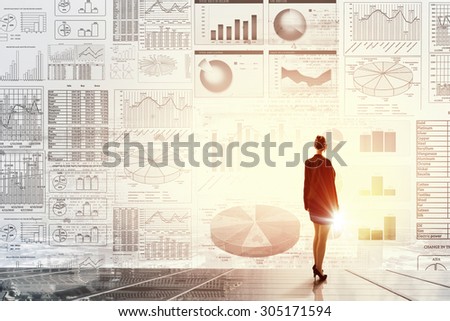 Rear view of businesswoman with suitcase and diagrams on virtual panel