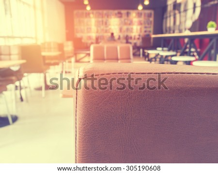 Vintage style photo of the empty leather chair in coffee shop.