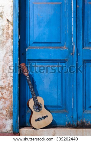 A viola (brazilian typical 10 strings guitar) standing in the old doorway