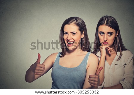 Two women optimistic lady having solution and bored, annoyed clueless sad woman on gray wall background. Human emotion face expression feeling, life approach. Bipolar disorder concept Royalty-Free Stock Photo #305253032