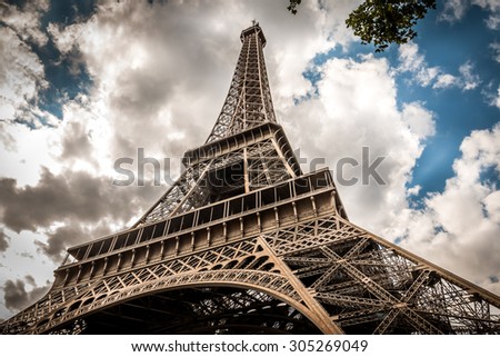 A dramatic perspective of the Eiffel Tower and a moody cloudscape behind it in Paris, France. 