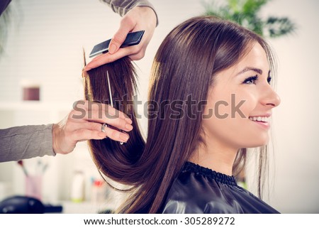 Young beautiful woman having her hair cut at the hairdresser's. Royalty-Free Stock Photo #305289272
