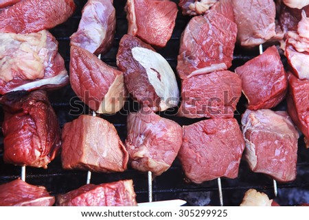 fresh raw turkey fillet steak red meat brisket on skewers barbecue brazier grid full burned charcoal
