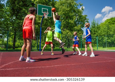 Team in colorful uniforms playing basketball game Royalty-Free Stock Photo #305326139