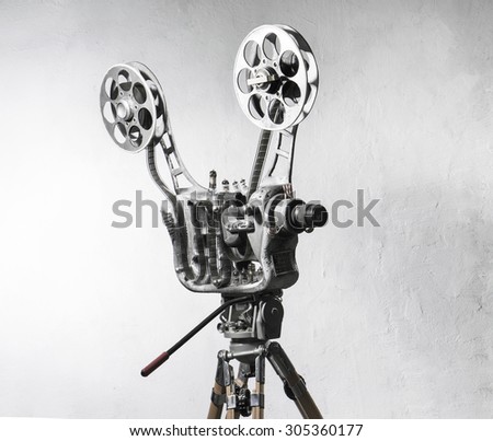 Movie projector with the film on the background of gray wall