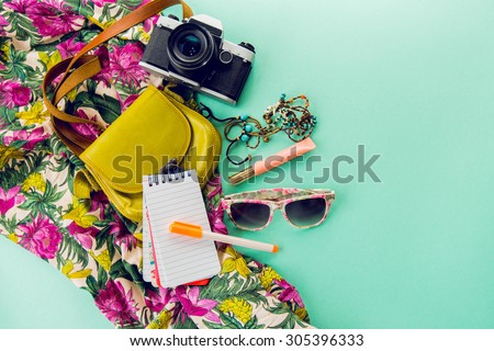 Close up lifestyle photo of hipster student accessories . Still life of random objects of modern girl / woman. Leather bag, camera, Sunglasses, paper notepad, Aerial view. Sunny summer colors. Royalty-Free Stock Photo #305396333