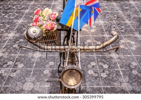 Vintage bicycle with a flag on top .