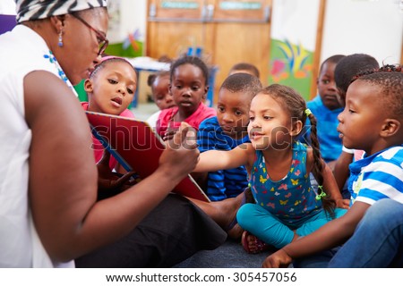 Teacher reading a book with a class of preschool children Royalty-Free Stock Photo #305457056