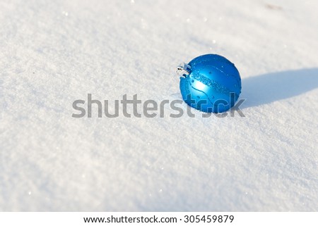 Blue Christmas ball lies on a snow