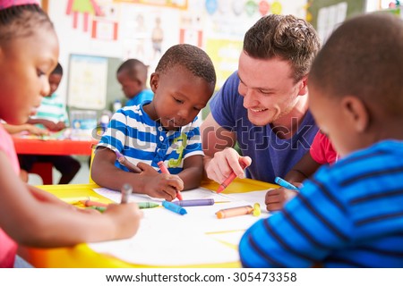 Volunteer teacher helping a class of preschool kids drawing Royalty-Free Stock Photo #305473358