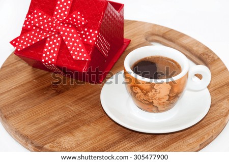 Coffee cup and red box with a bow.
