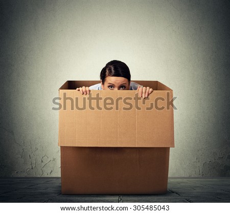 Young woman hiding in a carton box Royalty-Free Stock Photo #305485043