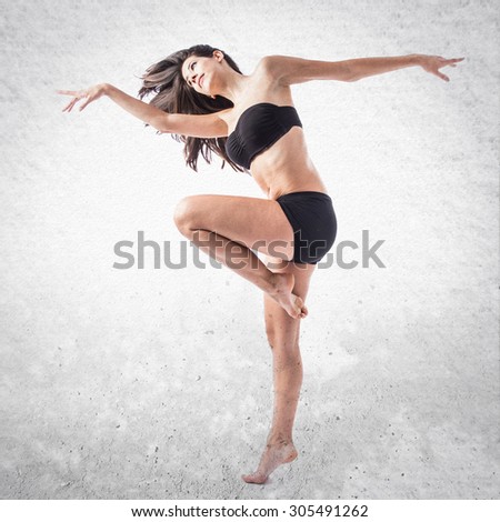 Pretty fitness female posing over textured background 