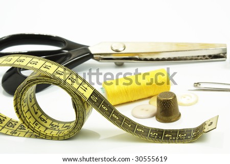 collection of sewing tools and supplies in a sewing kit, isolated on a white background