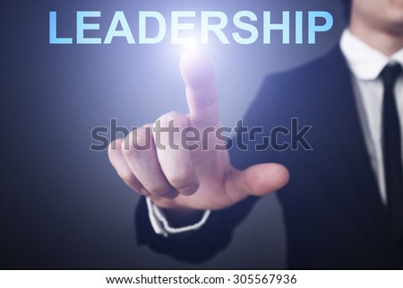 Businessman pressing button on virtual touch screen  and select "leadership". Business concept. Internet concept.