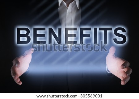 Businessman holding a tablet pc with "Benefits" text on virtual screen. Business concept. Internet concept.
