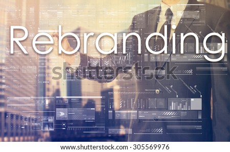 businessman writes on board text: Rebranding - with sunset over the city in the background, the visible sun's rays in a picture are symbolizing the positive attitude