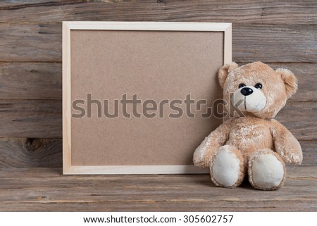 Teddy bear and photo frame on wood
