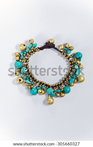 Bracelet  with gold and blue stones isolated on white Selective focus point
