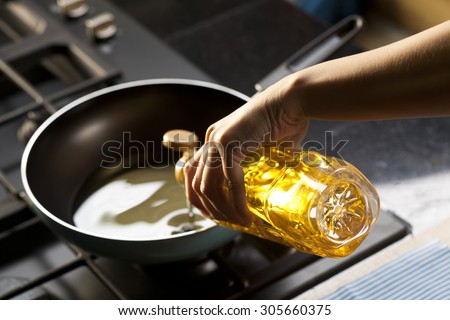 Pouring vegetable oil into frying pan
 Royalty-Free Stock Photo #305660375