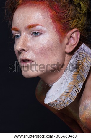 Art picture of a girl with creative make-up, textured leather, red-orange tones on a black background