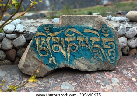 Carved stone tablet with inscription Om Mani Padme Hum in Tibet, China 