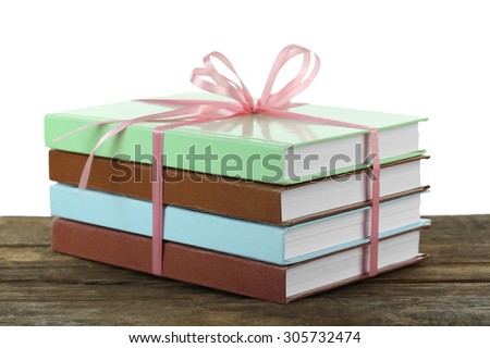 Stack of books with ribbon on light background