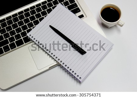 Blank notepad, laptop and coffee cup on office
