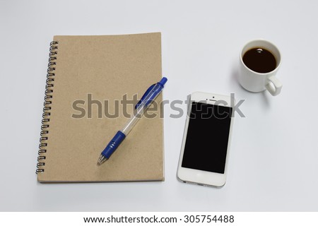 phone with a cup of coffee, a notebook and pen