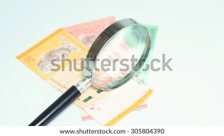 Magnifier with Malaysia Bank Notes.Selective focus and shallow depth of field.
