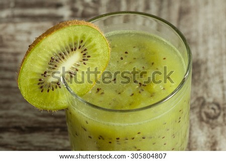green kiwi juice, smoothie on wooden background. healthy drink in a glass. diet. summer drink and refreshment.
