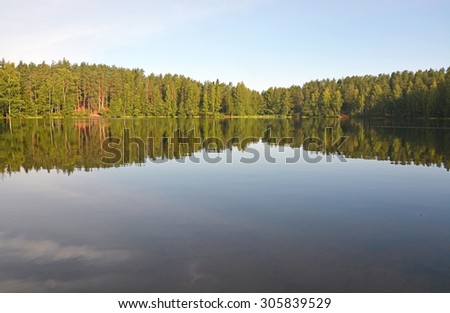 Calm forest lake with reflections, called Chertovo lake. Russia, Saint-Petersburg region