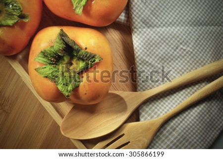 vintage persimmons on wooden table focus on one point with lens vignetting