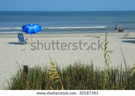 beach scene with chair, umbrella and ocean