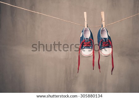 Baby shoes hanging on the clothesline Royalty-Free Stock Photo #305880134