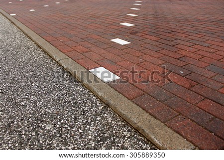 Parking space markings made with white colored tiles.
