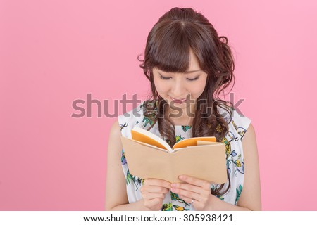 happy young japanese woman reading storybook.