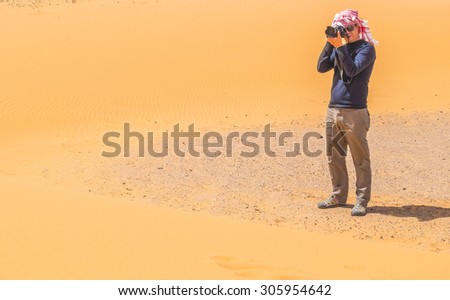 Toourist taking pictures on sand dunes in Merzouga, Morocco