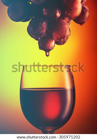 Wine glass with red wine and grapes. Filtered image: vintage effect.