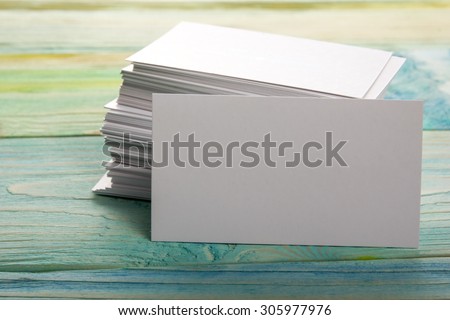 White blank business visit card, gift, ticket, pass, present close up on blurred blue background. Copy space
Blank corporate identity package business card 
Template for ID. 