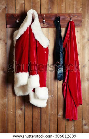 Santa costume hanging on wooden wall background