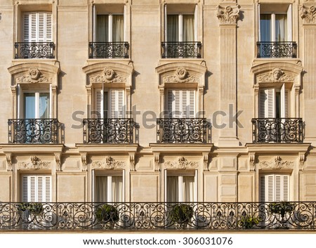 Typical facade of Parisian building with window wrought iron fences near Notre-Dame in French capital Royalty-Free Stock Photo #306031076