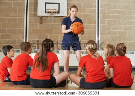 Coach Giving Team Talk To Elementary School Basketball Team Royalty-Free Stock Photo #306055391