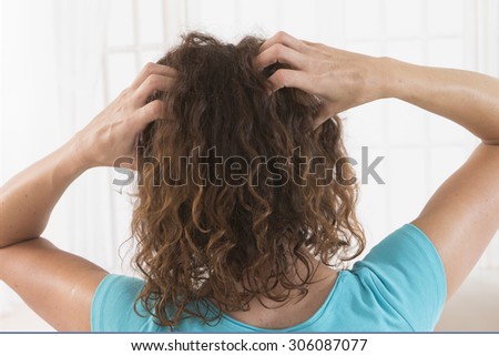 Woman suffering from an headache itching her head