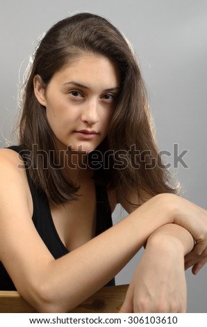 Portrait of a beautiful young woman standing against grey background